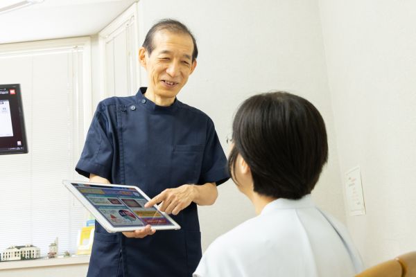 院長がiPadを使ってカウンセリングを行っている写真