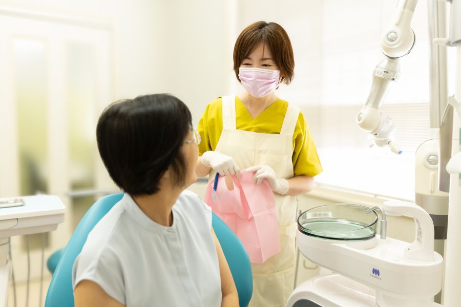 もりざね歯科医院のスタッフが患者さんと談笑している写真