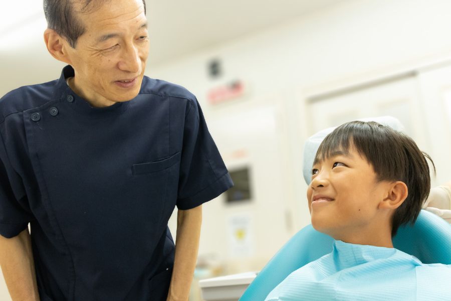 院長と小児の患者が笑顔で会話している写真