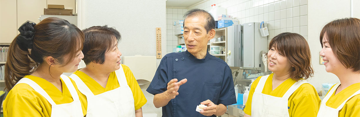 もりざね歯科医院の院長とスタッフがミーティングで談笑している写真